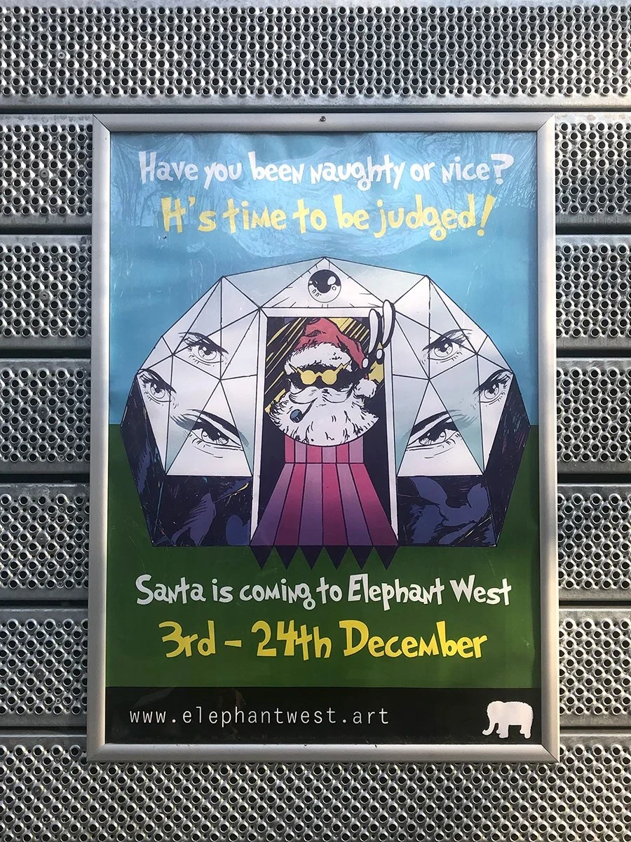 A promotional poster for an event at Elephant West from December 3rd to 24th features Santa Claus with an animal face inside a geometric structure with multiple eyes. The background has blue and green sections, with yellow and white text.