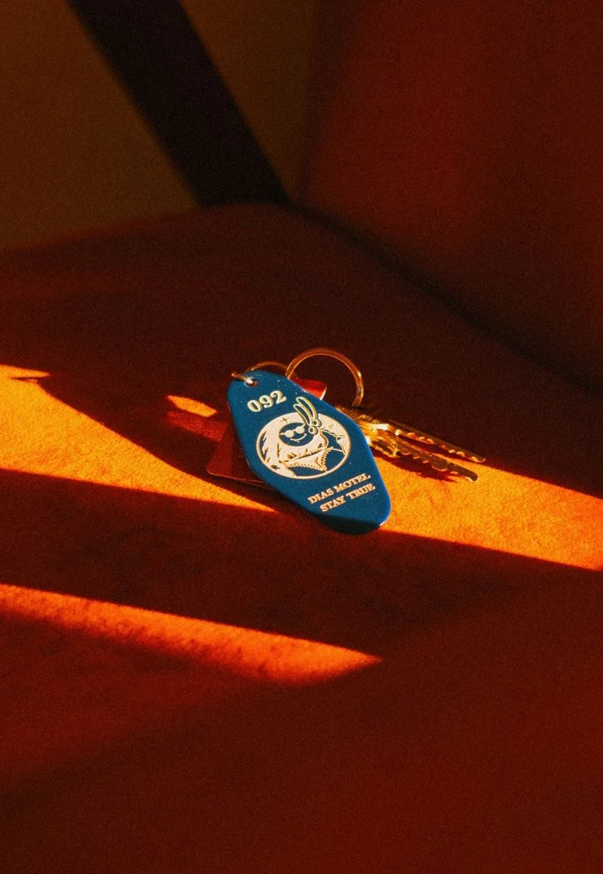 Yellow surface with a set of airline or hotel keycards and a key, with shadows cast by sunlight.