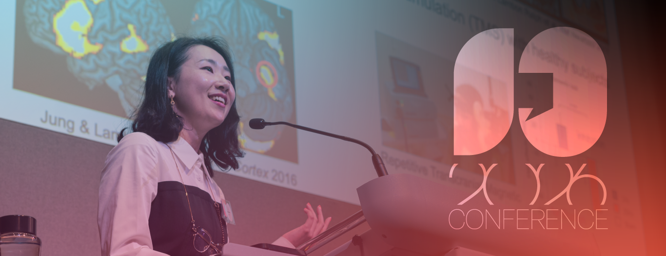 Brainbox Initiative 2026 website banner. A woman giving a presentation at a conference, with a large logo overlay.