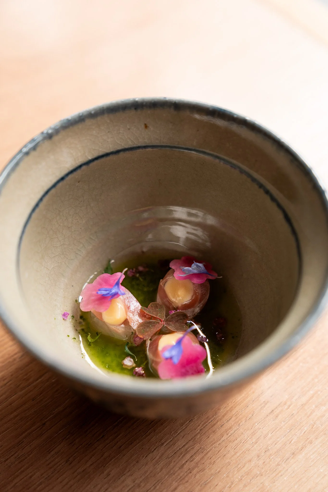 Sunomono dish at TAKU: Cornish sea bass with sumiso seasoning, shiso oil, and seasonal pickled radish, served as a refreshing palate cleanser