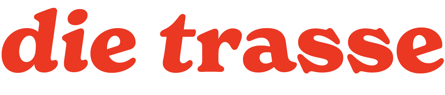 Der Schriftzug 'die trasse' in großen roten Buchstaben auf schwarzem Hintergrund.