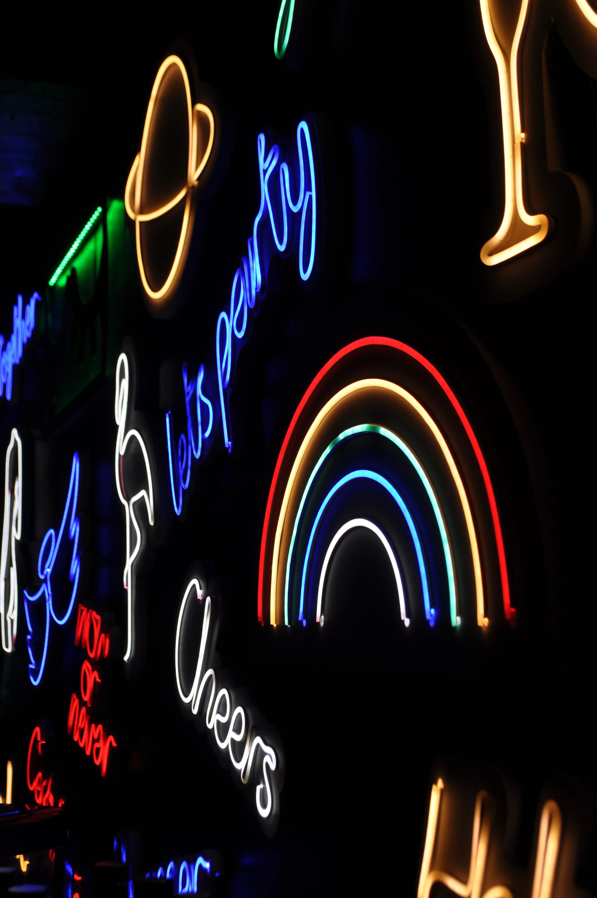 Neons colorés représentant un arc-en-ciel avec texte en français : 'Le meilleur des bisous'.