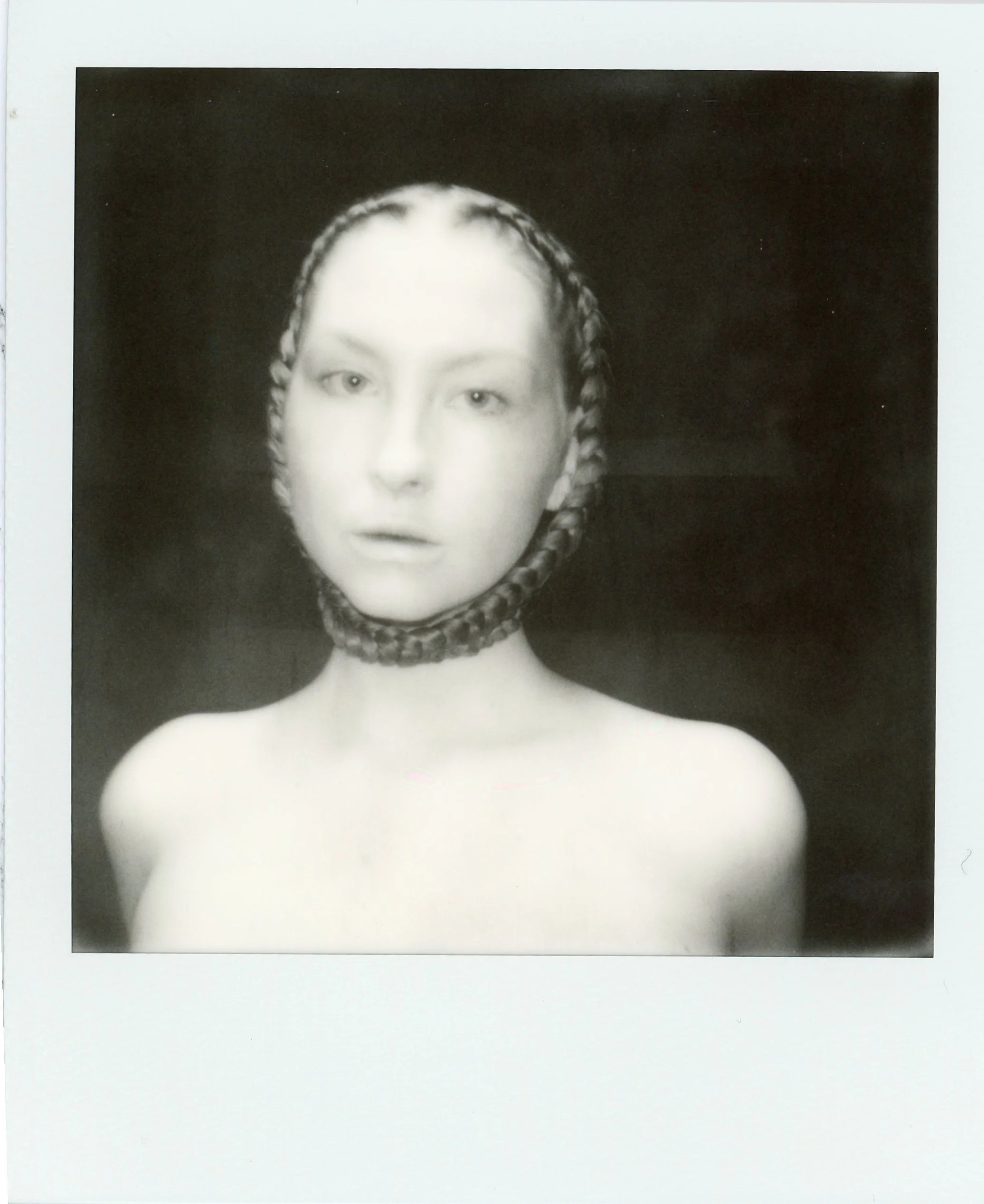 Photographie en noir et blanc d'une femme avec la tête et le cou entourés d'une corde, le visage étant la seule partie visible.