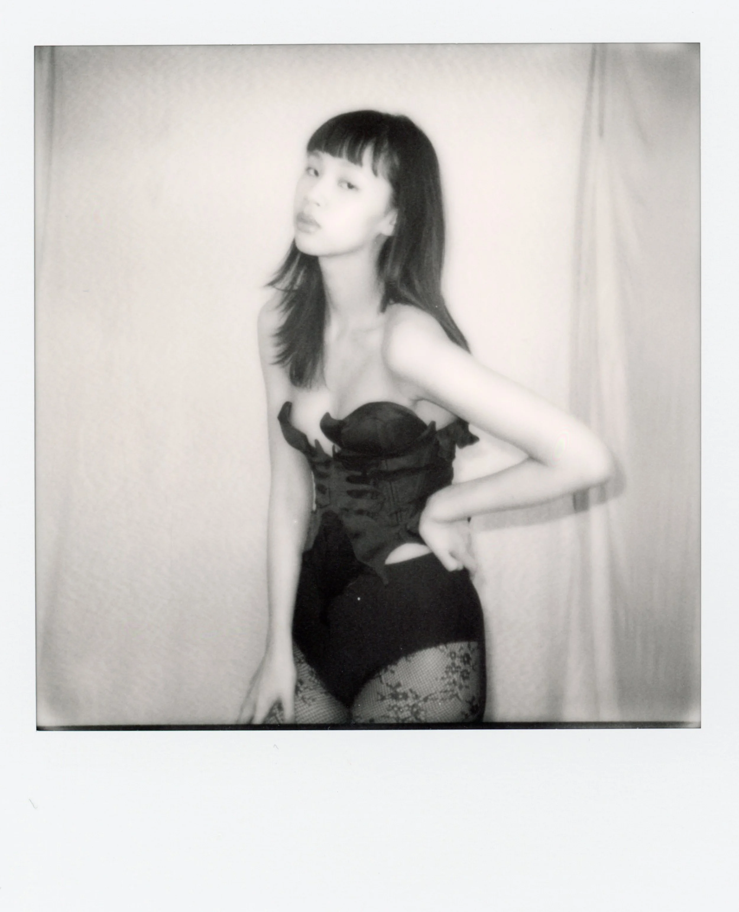 Une femme porte une tenue en lingerie noire avec des bas en crochet.