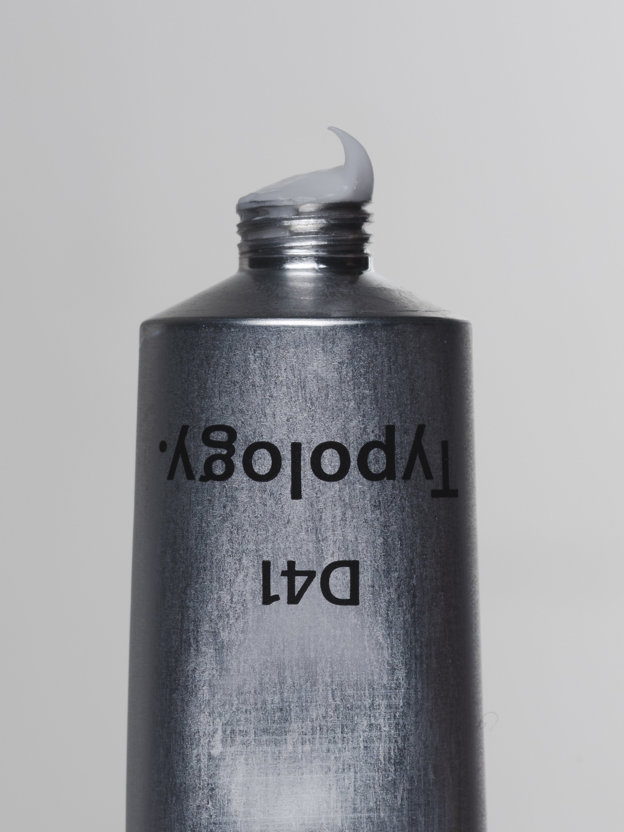 Tube de crème avec une quantité de crème blanche au sommet, marqué 'D4T Polypysy'.