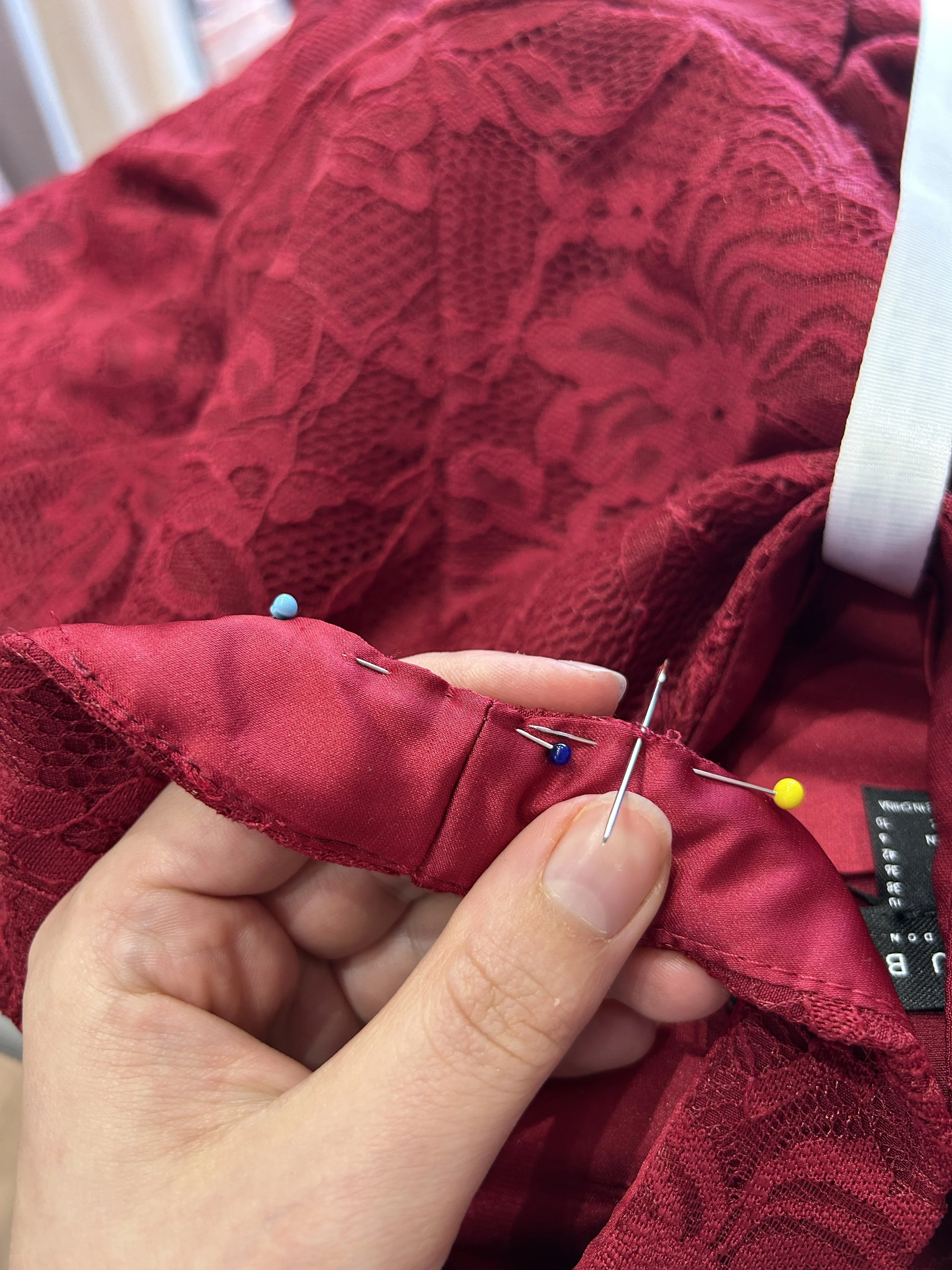 seamstress Ellie repairing straps on an occasion dress