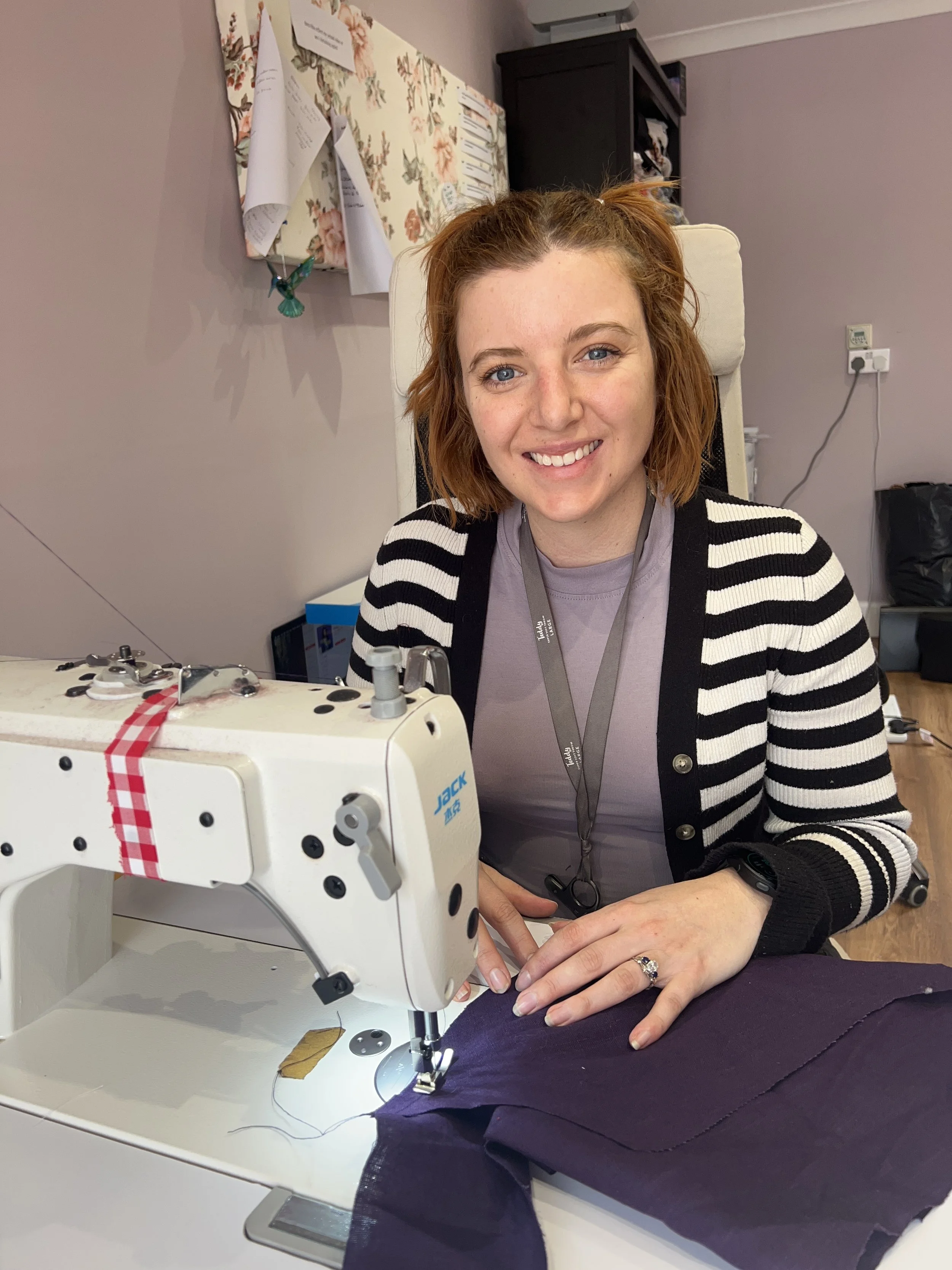 sustainable dressmaker Ellie sat in her lilac sewing room
