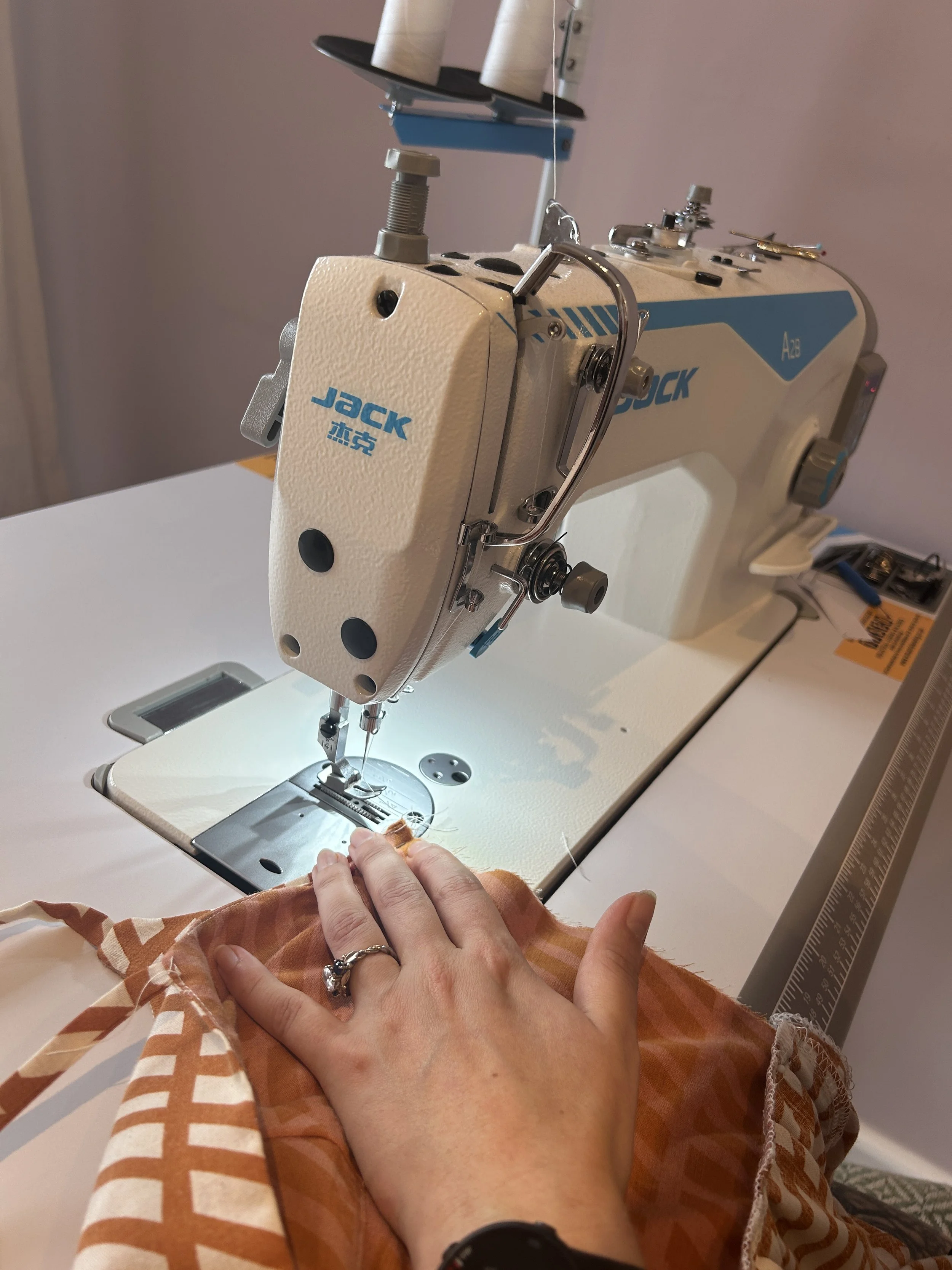 upcycler and artisan stitcher Ellie creating a bespoke dress on an industrial sewing machine