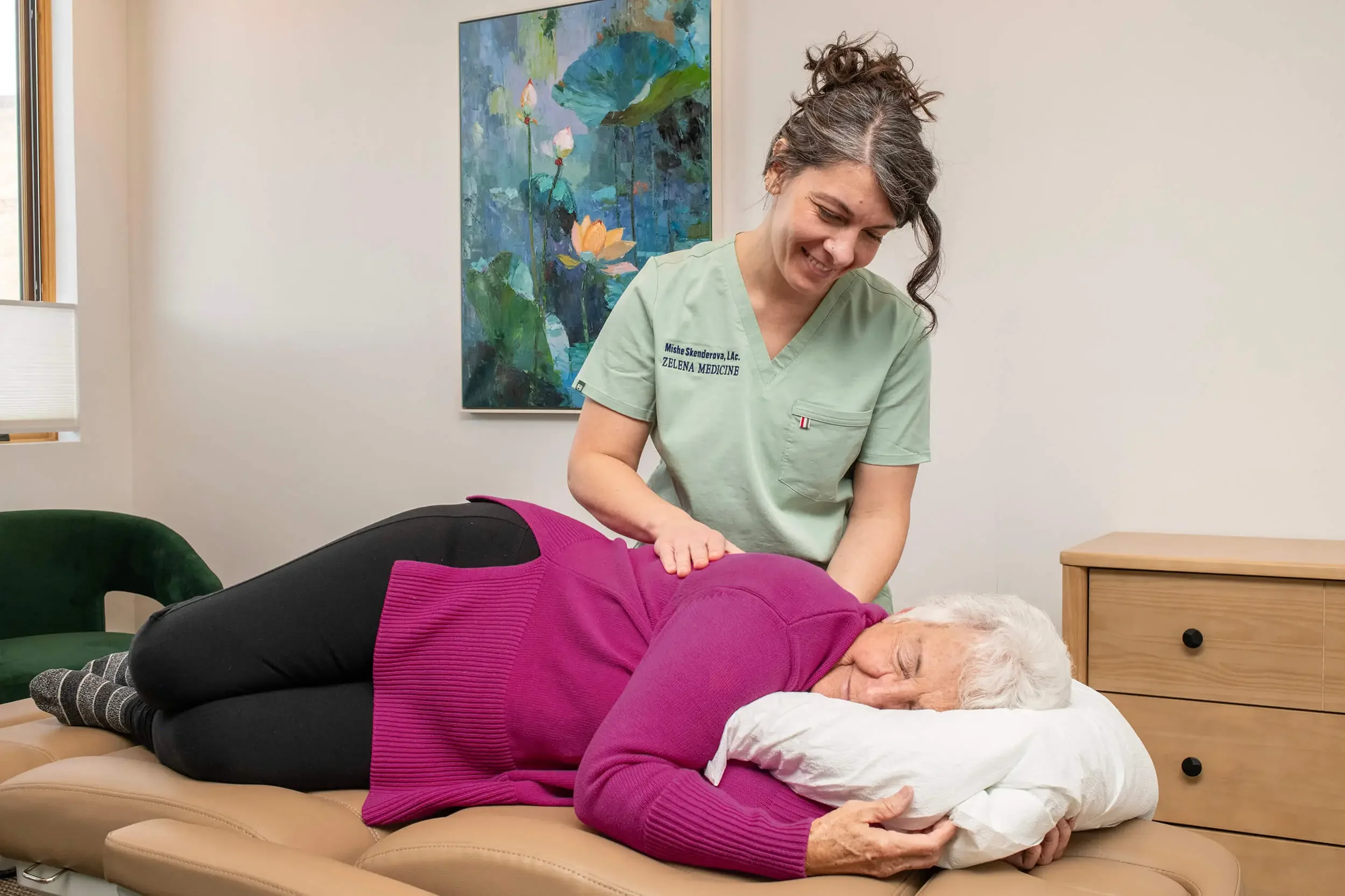 Mishe Skenderova, acupuncturist at Zelena Medicine in Basalt, Colorado doing acupuncture treatment on older woman.