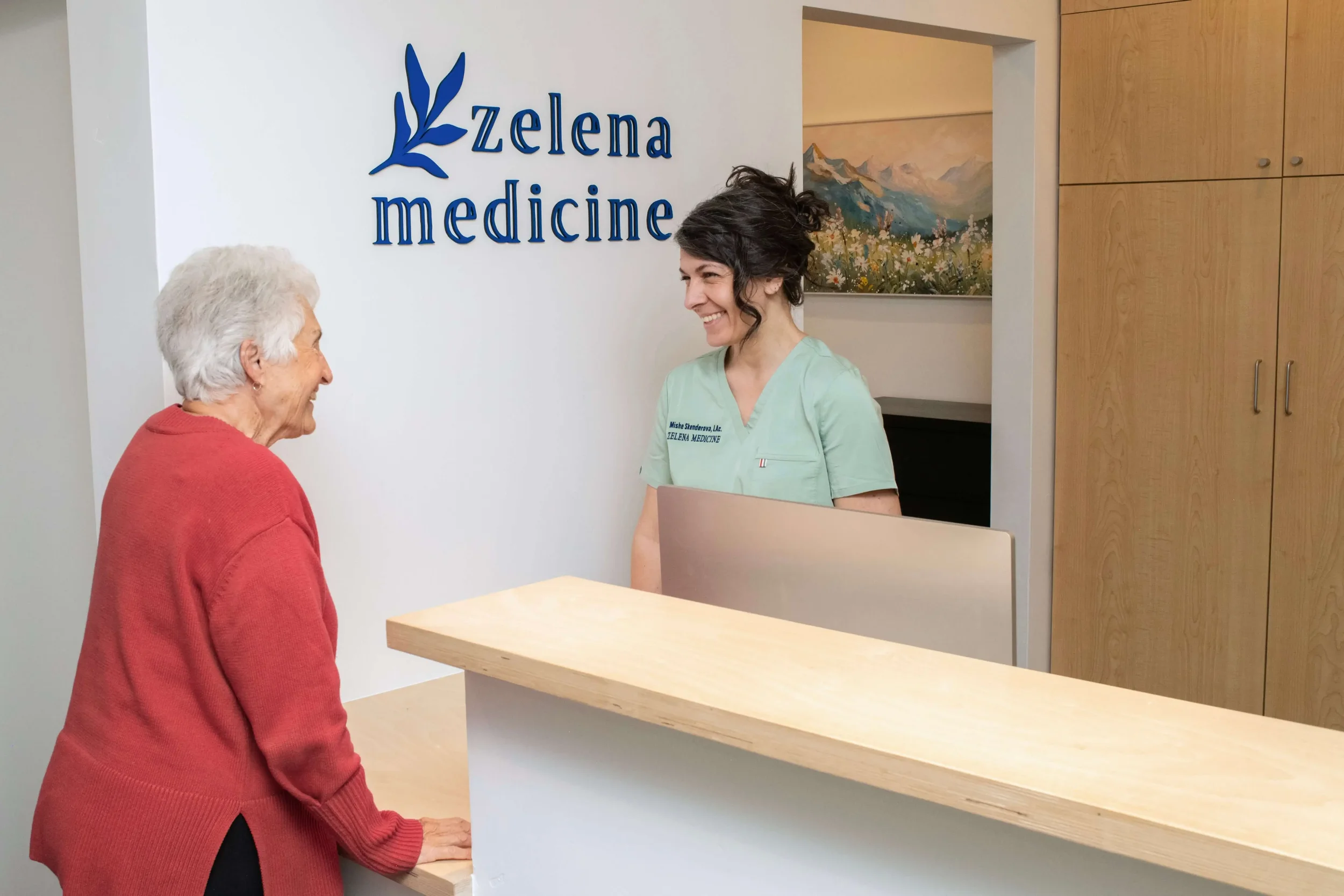 Mishe Skenderova, acupuncturist at Zelena Medicine in Basalt, Colorado talking with patient at front desk.