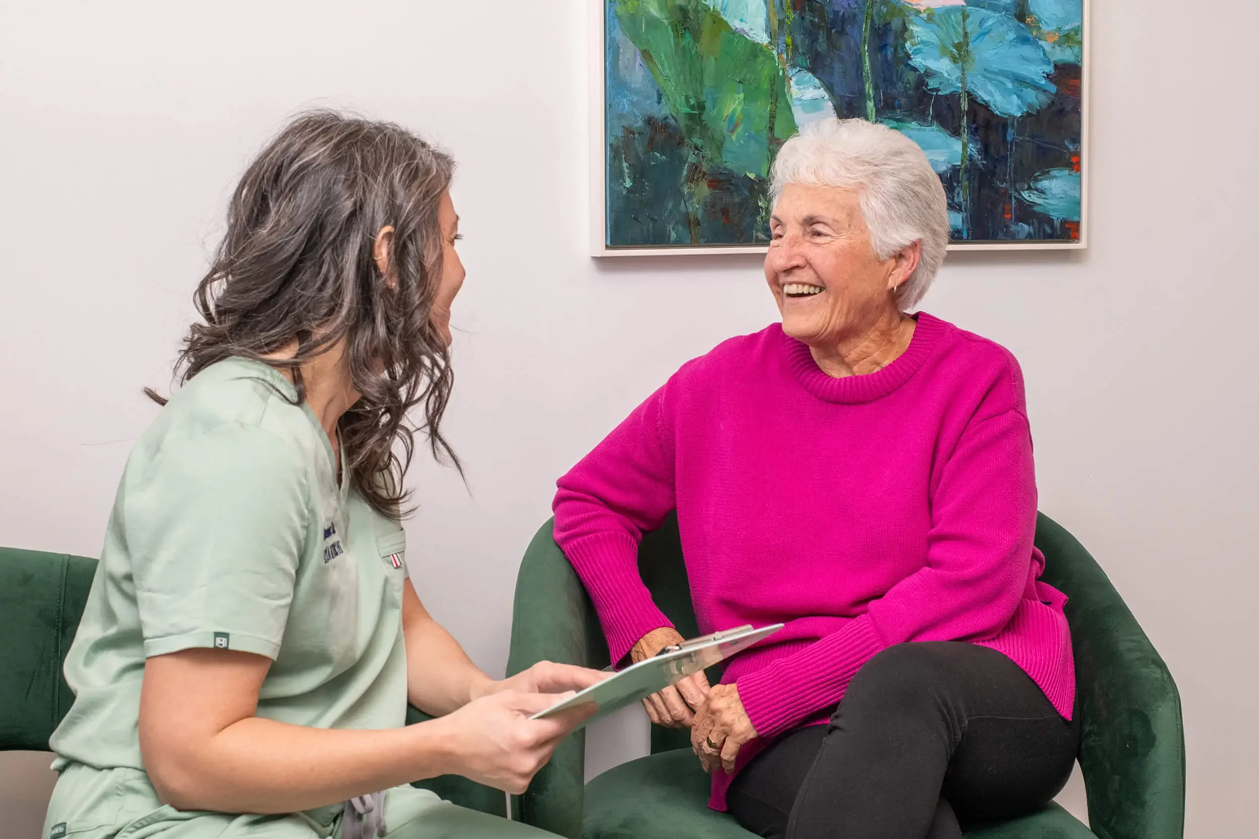 Mishe Skenderova, acupuncturist at Zelena Medicine in Basalt, Colorado and an elderly woman are sitting and engaging in a cheerful conversation.