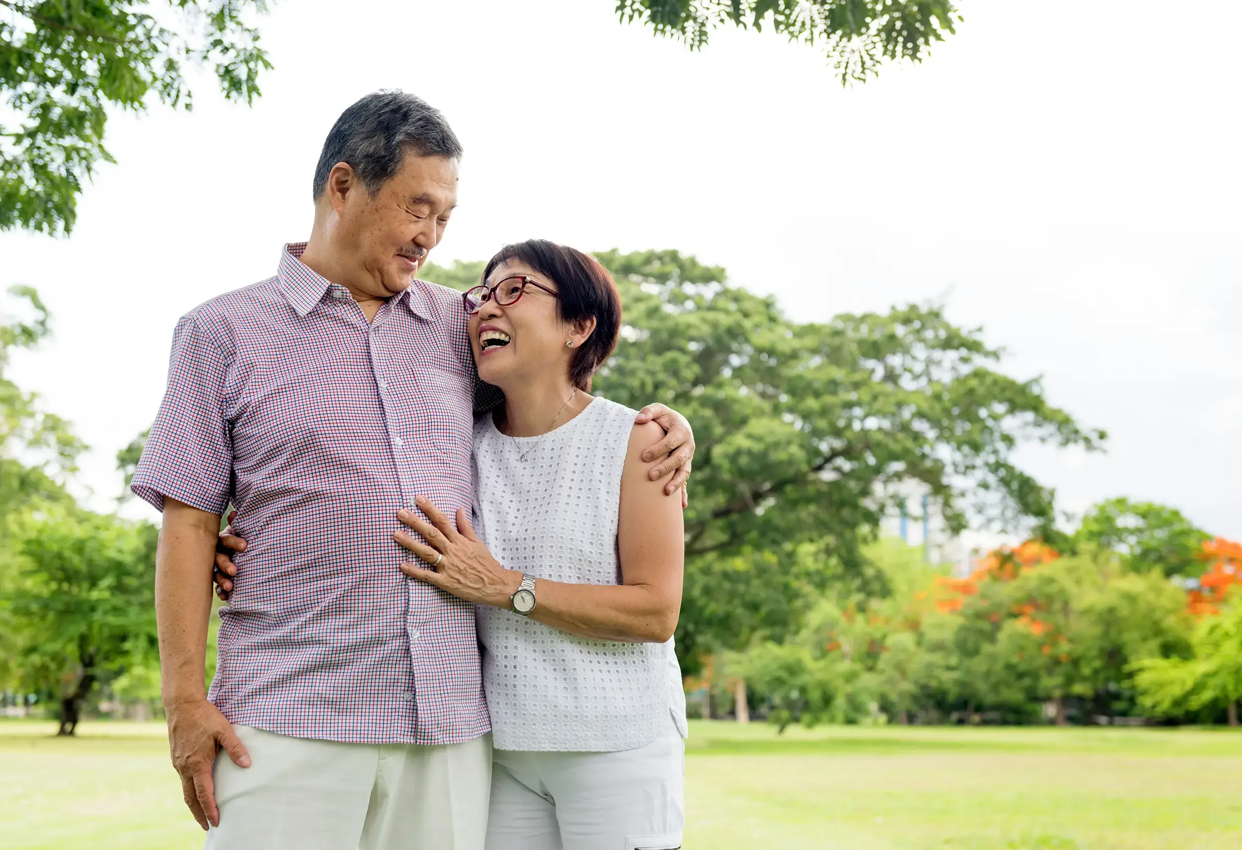An elderly man and woman smiling and hugging outdoors after cancer support treatment at Zelena Medicine in Basalt, Colorado