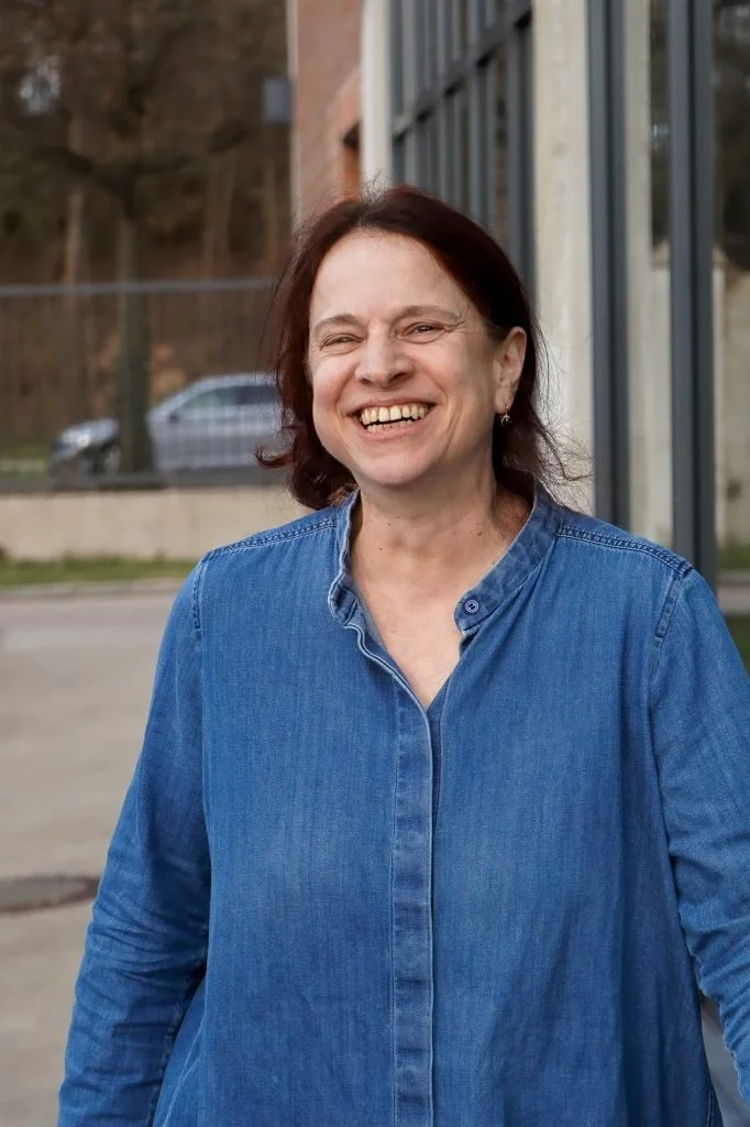 Foto von Christina Ruf. Lächelnde Frau mit halblangen rot-braunen Haaren. Sie trägt eine Jeans-Bluse.