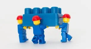 Children playing with a blue and red LEGO creation.