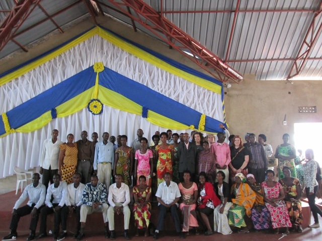 Group of people posing in front of a decorated backdrop at an indoor event.