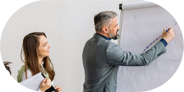 Male project manager writing on a whiteboard in an office