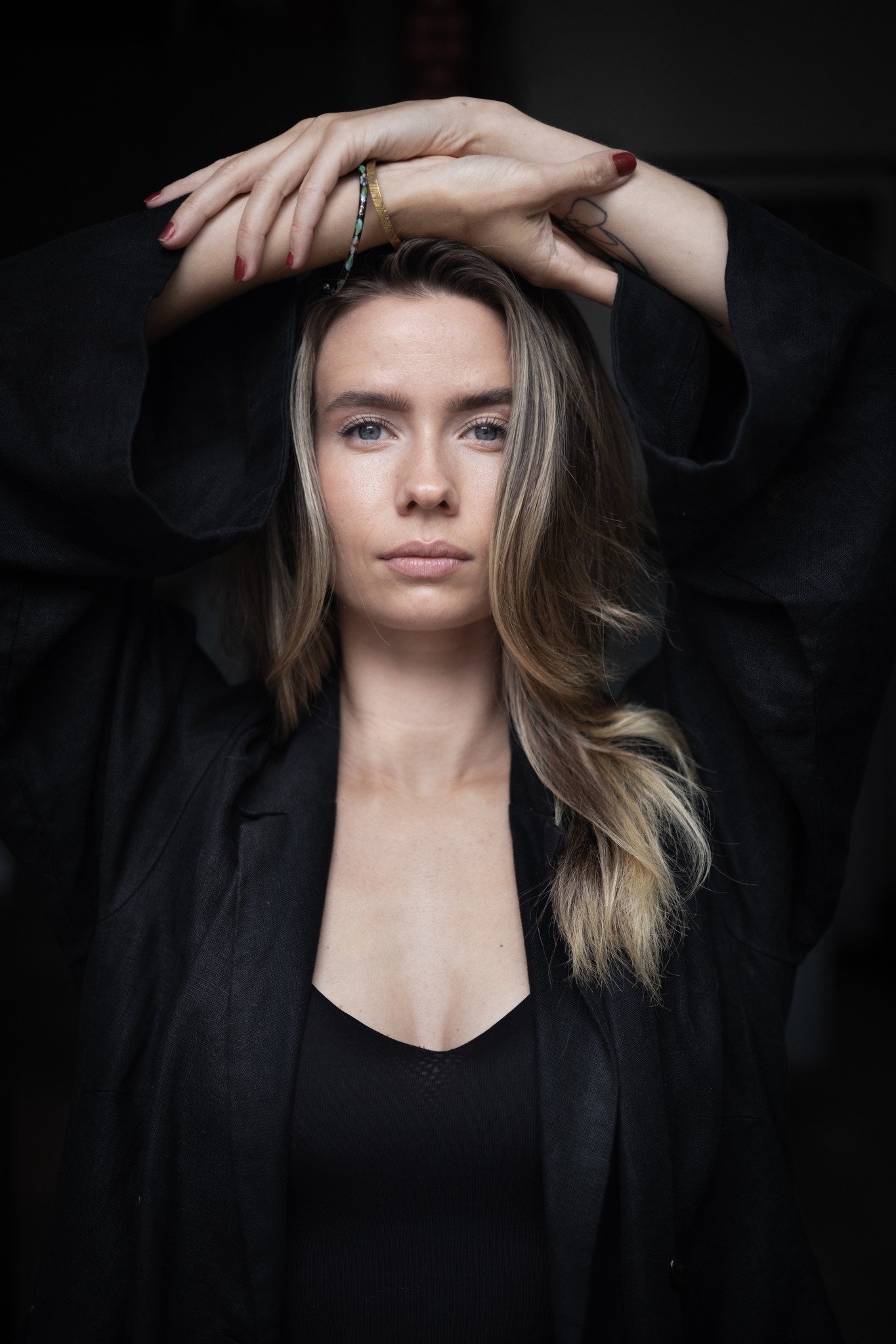 Ung dame med langt hår, alvorlig, armene ligger på toppen av hodet © Sofie Almasvold
