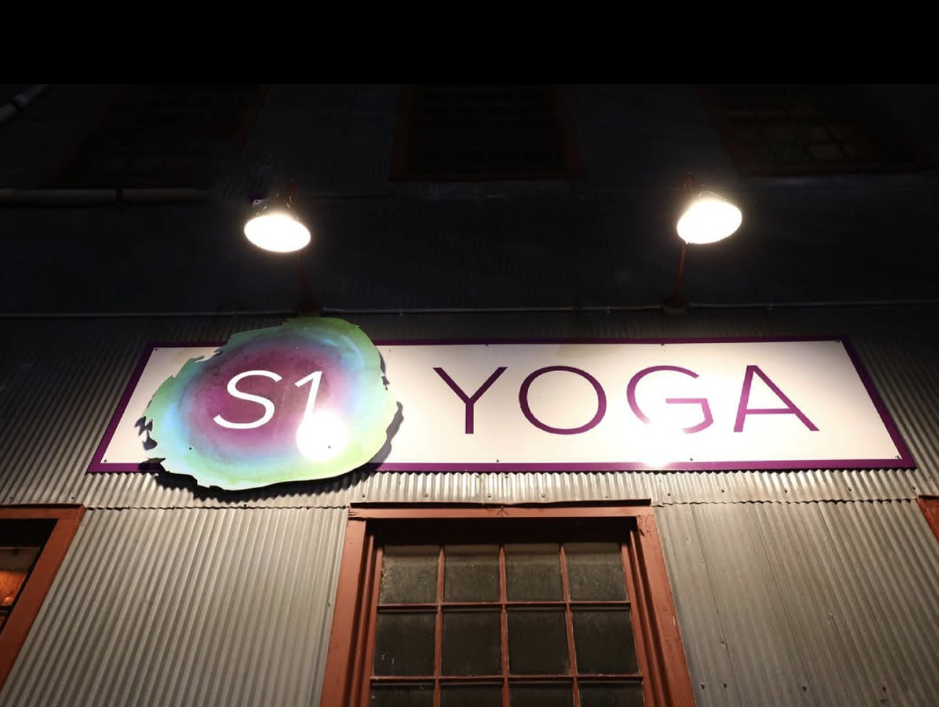 Single lit Studio One Yoga sign on a a dark night