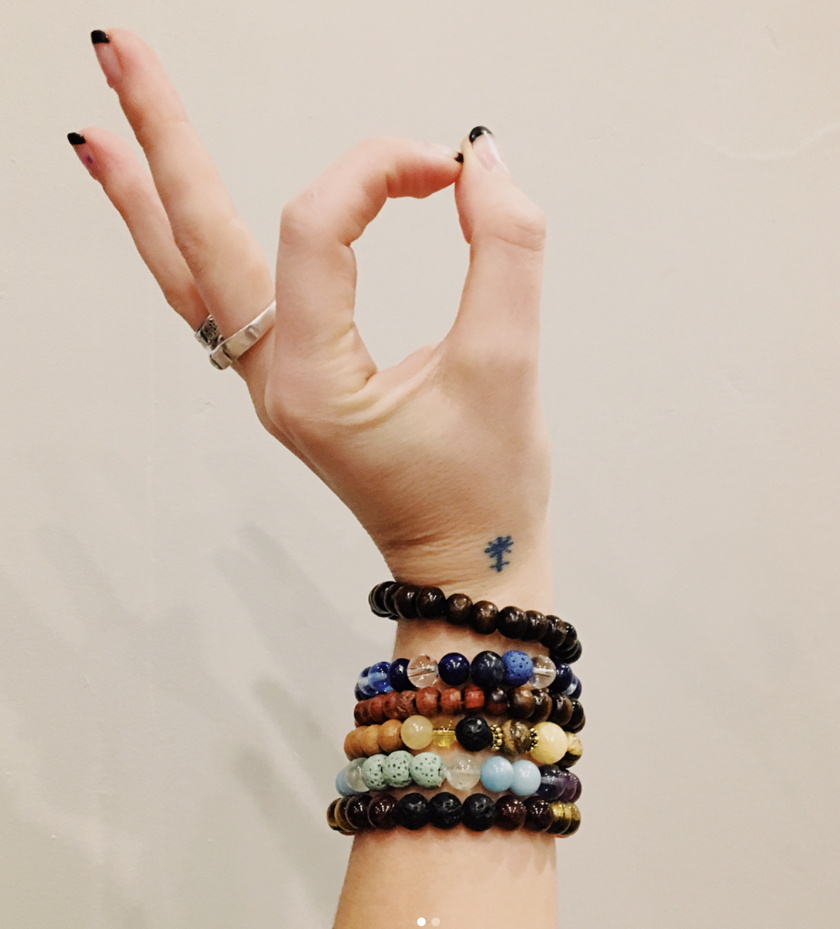 Hand in mudra with Moxie Mala bracelets at studio One Yoga