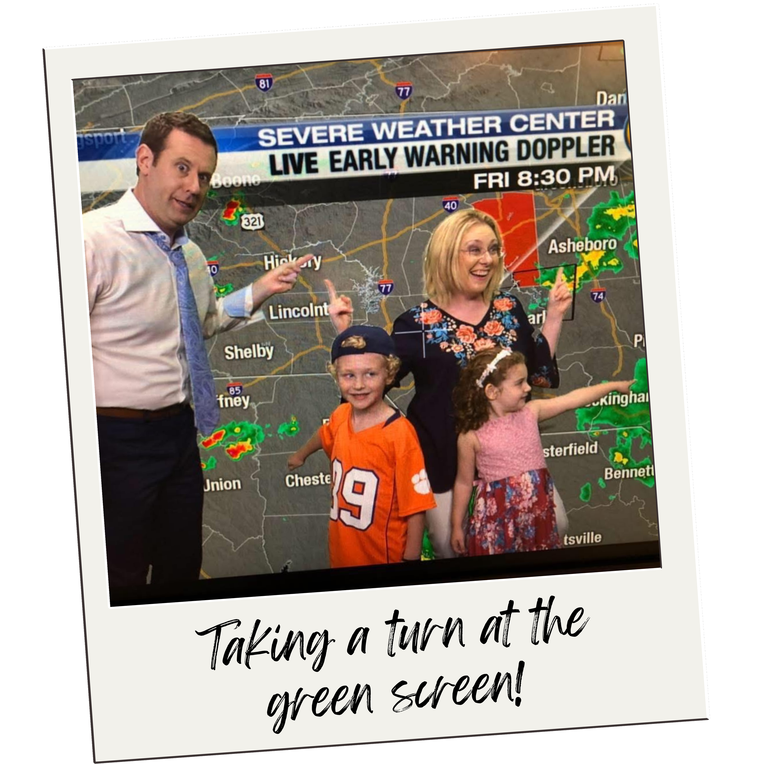 A group of four people, two adults and two children, standing in front of a weather forecast screen displaying rain and storm warnings. The adults are pointing to the weather map, and everyone is smiling. The image appears to be a photo taken from a television, with a caption that reads "Taking a turn at the green screen!"