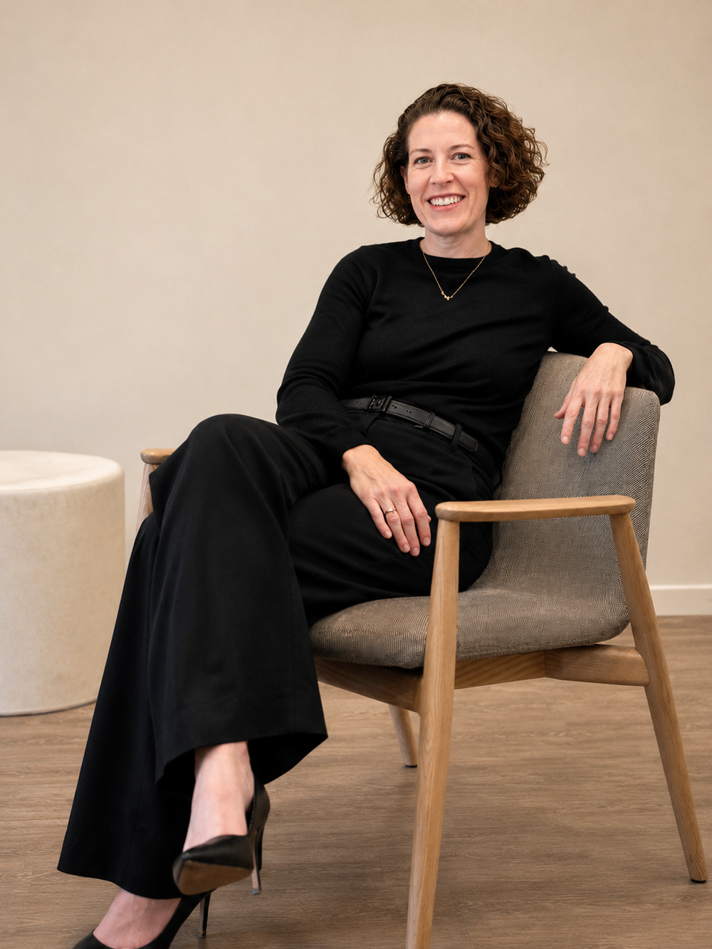 Melissa Pinson, founder of KP Kitchen Design, seated in an oak lounge chair