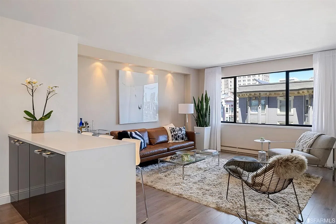 Living room before the renovation, with beige walls and the original kitchen