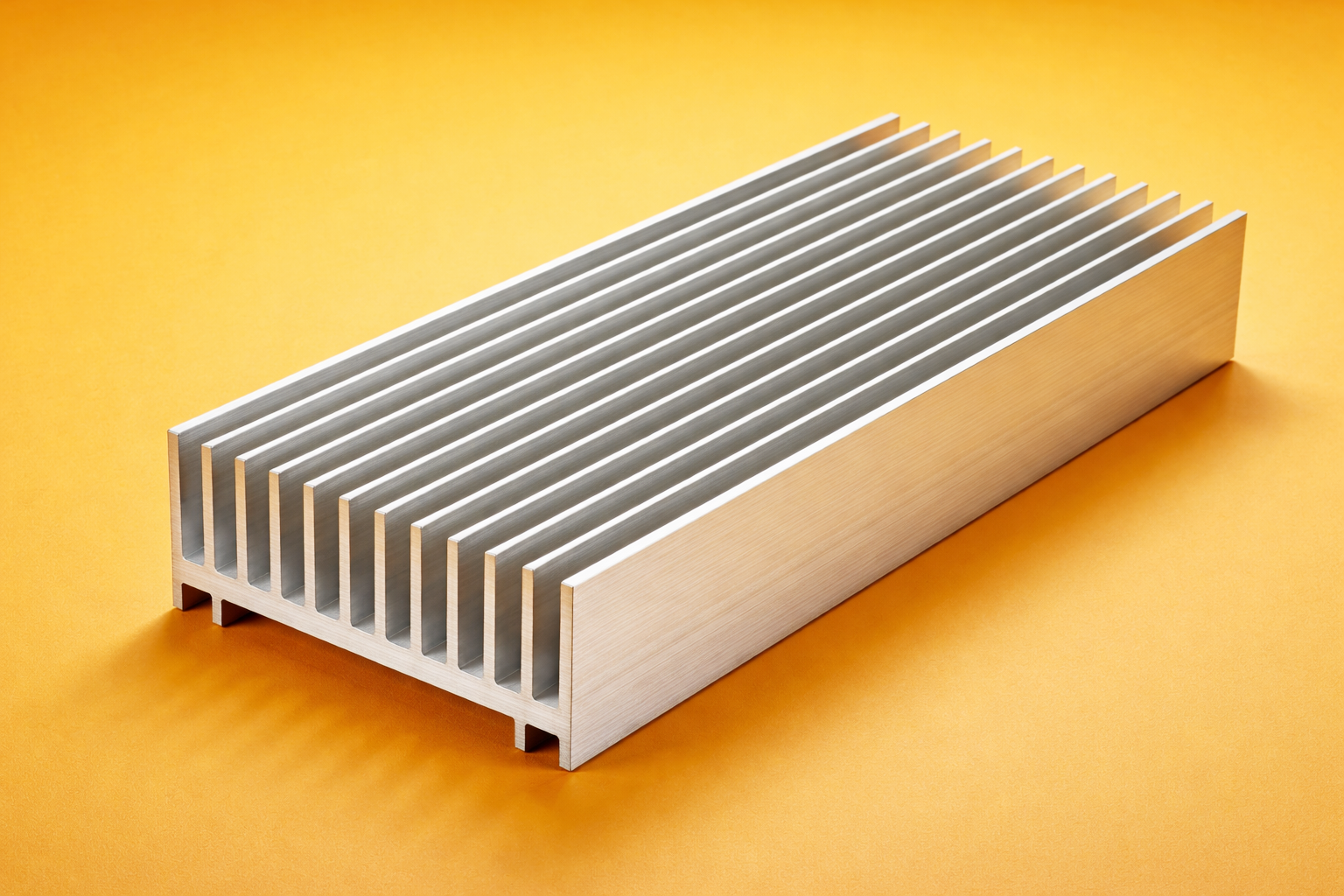 A rectangular metal object with parallel fins on a yellow background.