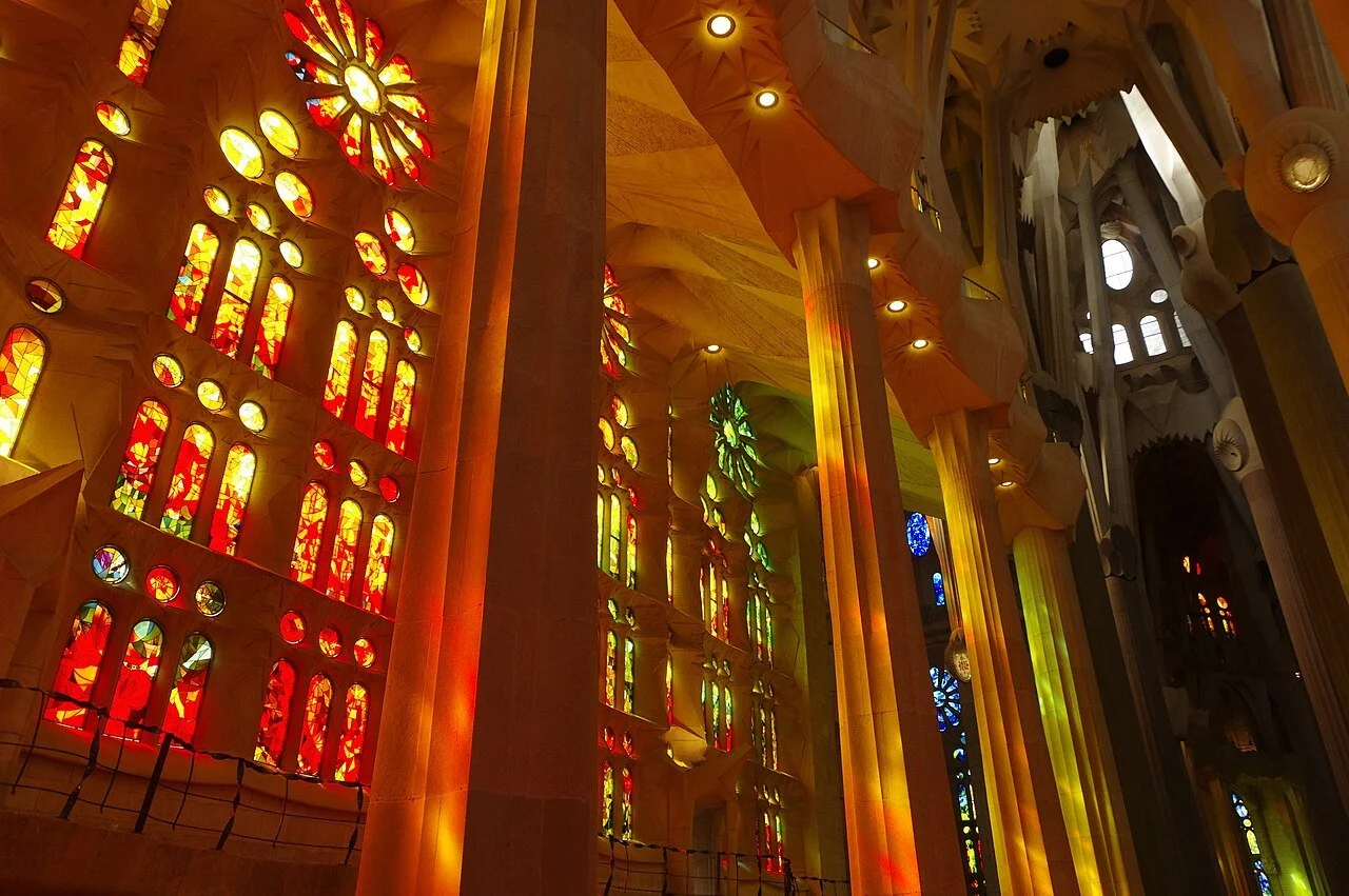 Luz natural a traves de vitrales color naranja en el interior de la Basilica de la Sagrada Familia de Antoni Gaudi