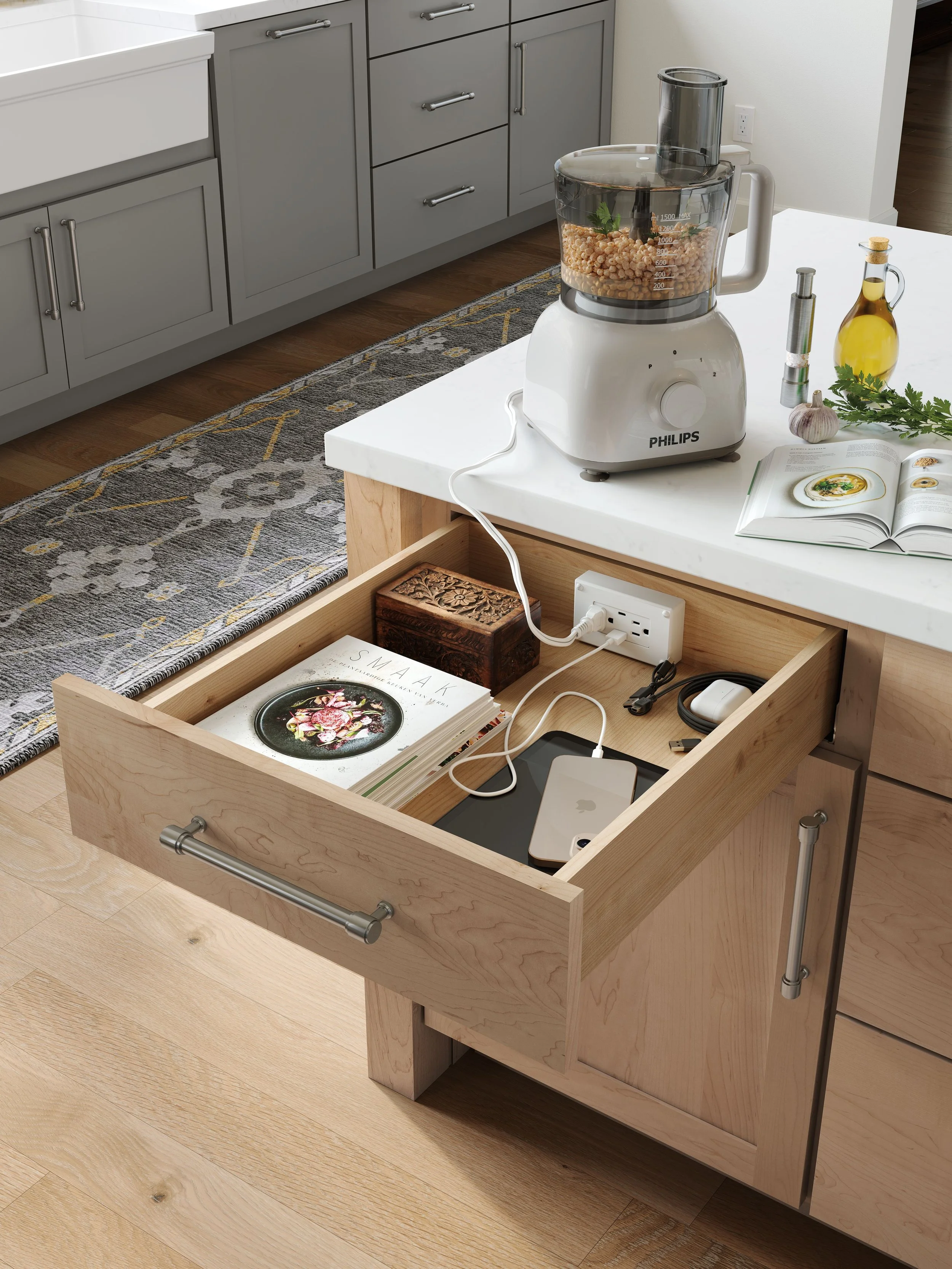 Kitchen island with a Philips food processor, open drawer with magazines and electronic devices, and a built-in power outlet.