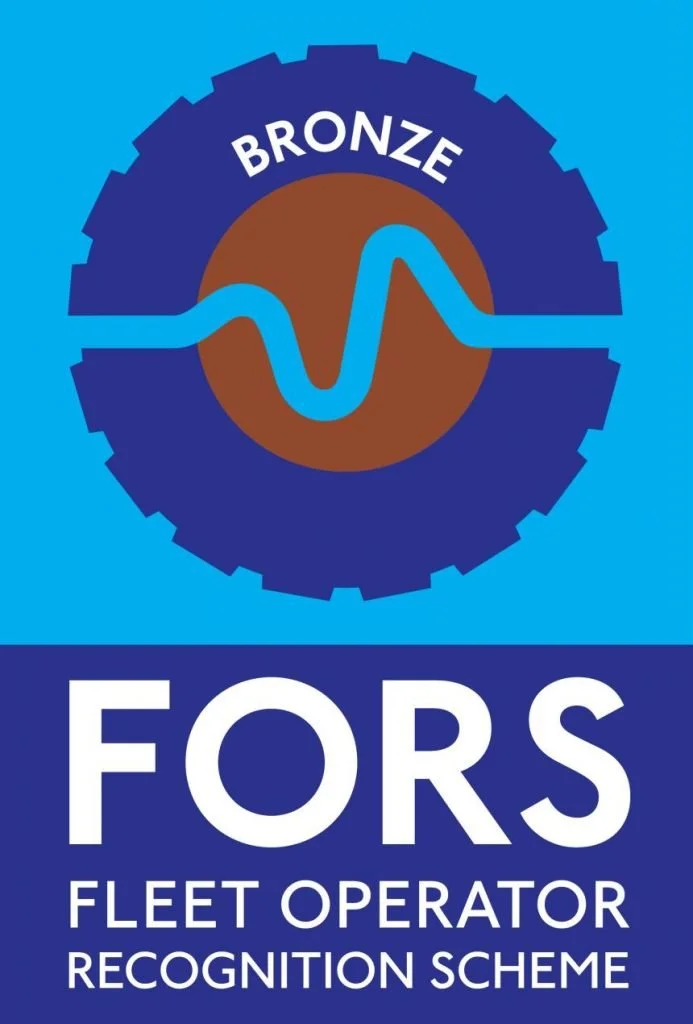 A logo with a blue gear and a brown circle inside, featuring a blue wave line, and the text 'BRONZE' at the top. Below, large white letters spell 'FORS,' with smaller text underneath saying 'FLEET OPERATOR RECOGNITION SCHEME' against a blue background.
