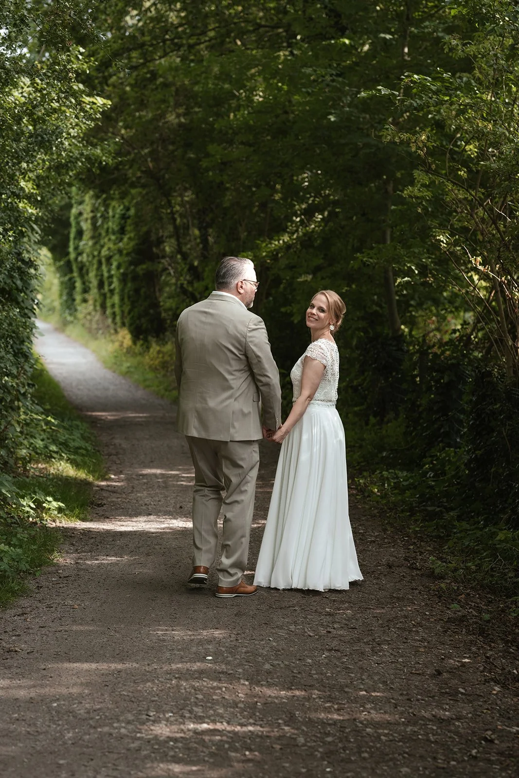 BRautpaar macht ein Spatziergang im Wald. 