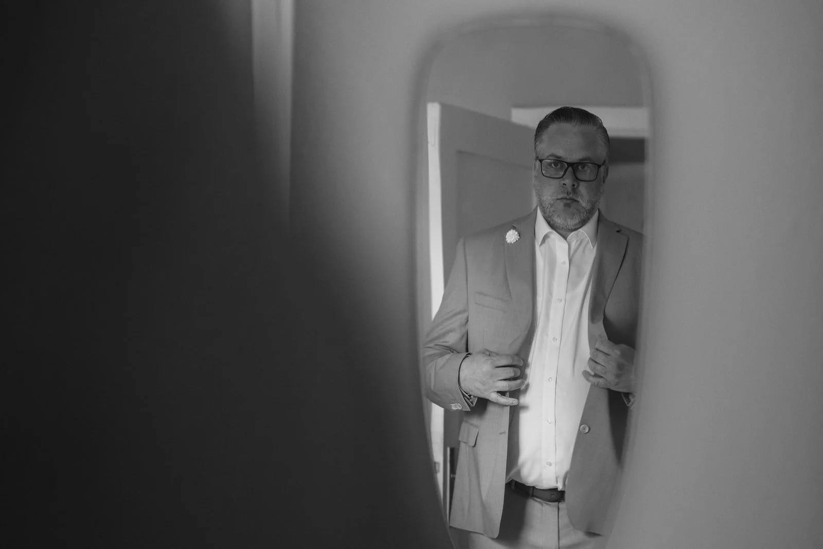 Bräutigam schaut sich im Spiegel an.