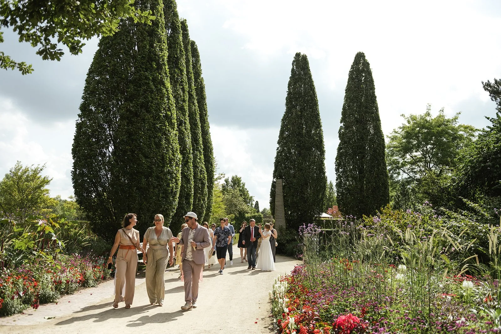 Hochzeitsgäste laufen im Park zur Trauung