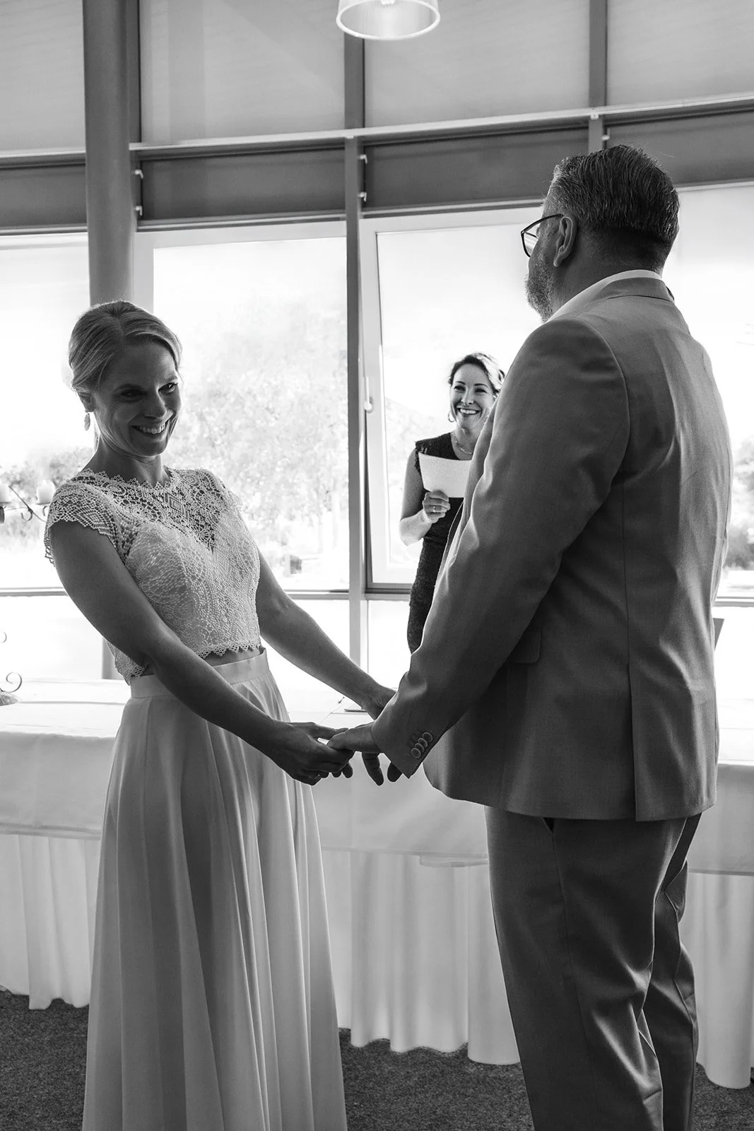 Paar halten Hände während der Trauung. Alle lachen.