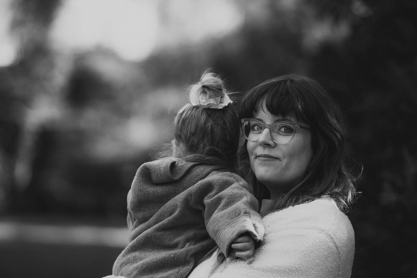 Mutter hält ihre Tochter im Arm. Sie schaut in die Kamera