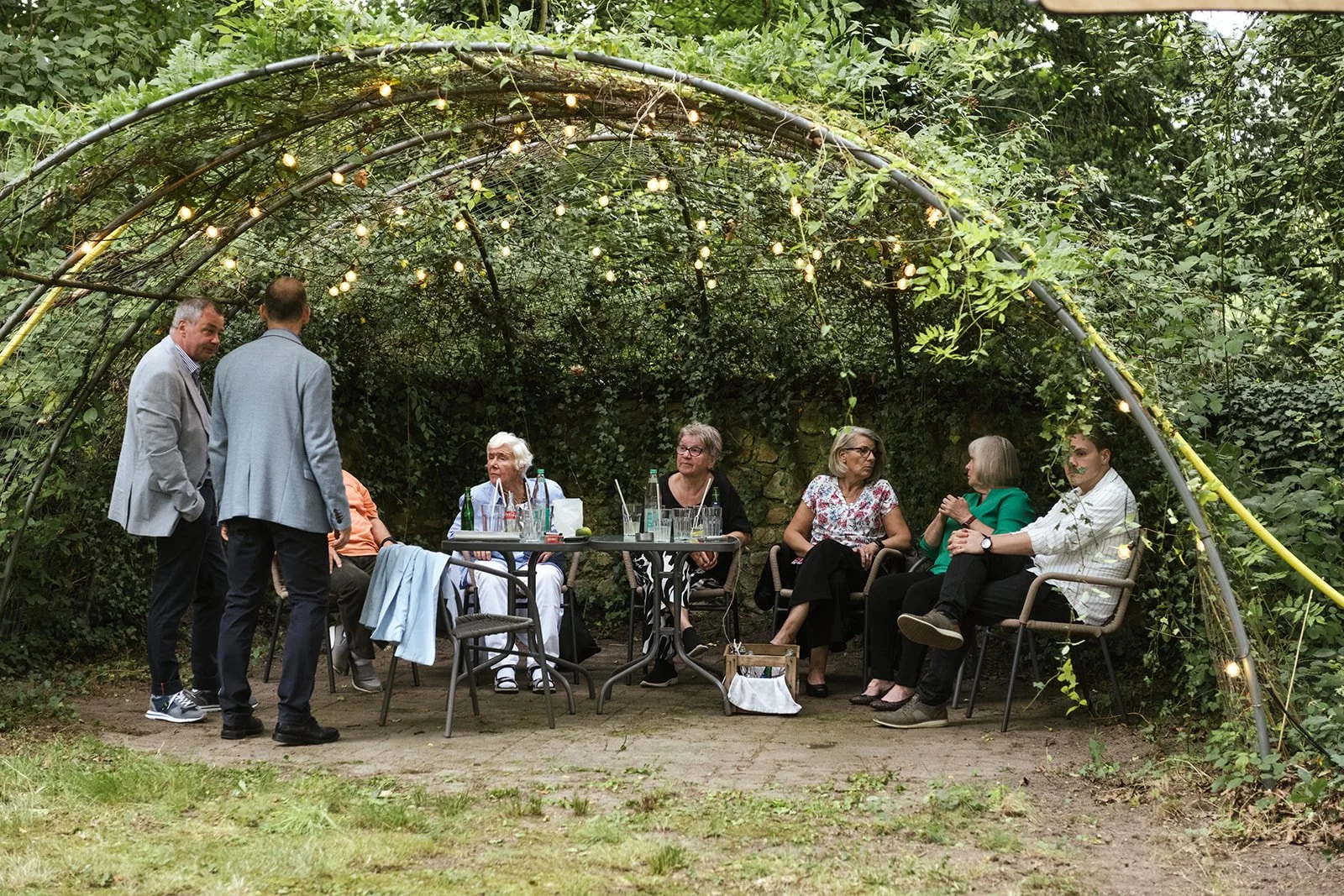 Hochzeitsgäste sitzen und relaxen nach der Trauung während der Gartenparty
