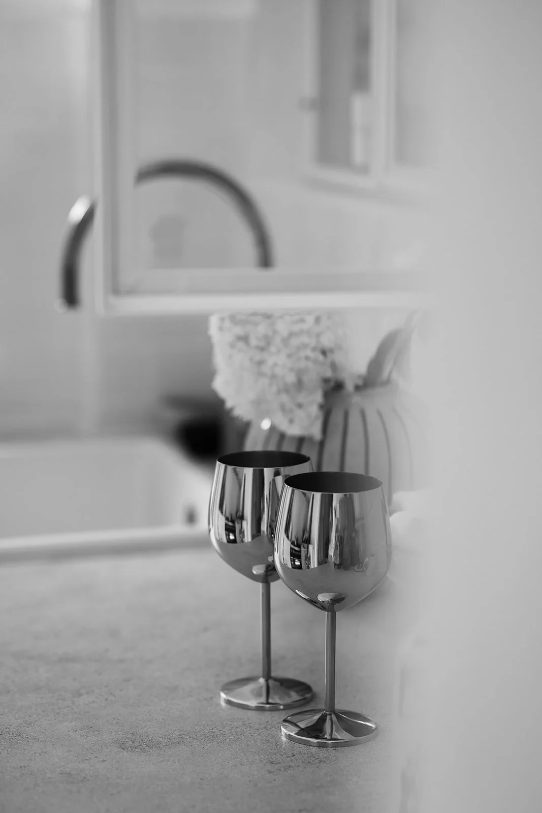 schwarz-weiss Aufnahme von zwei glanzenden Weingläser in der Küche.