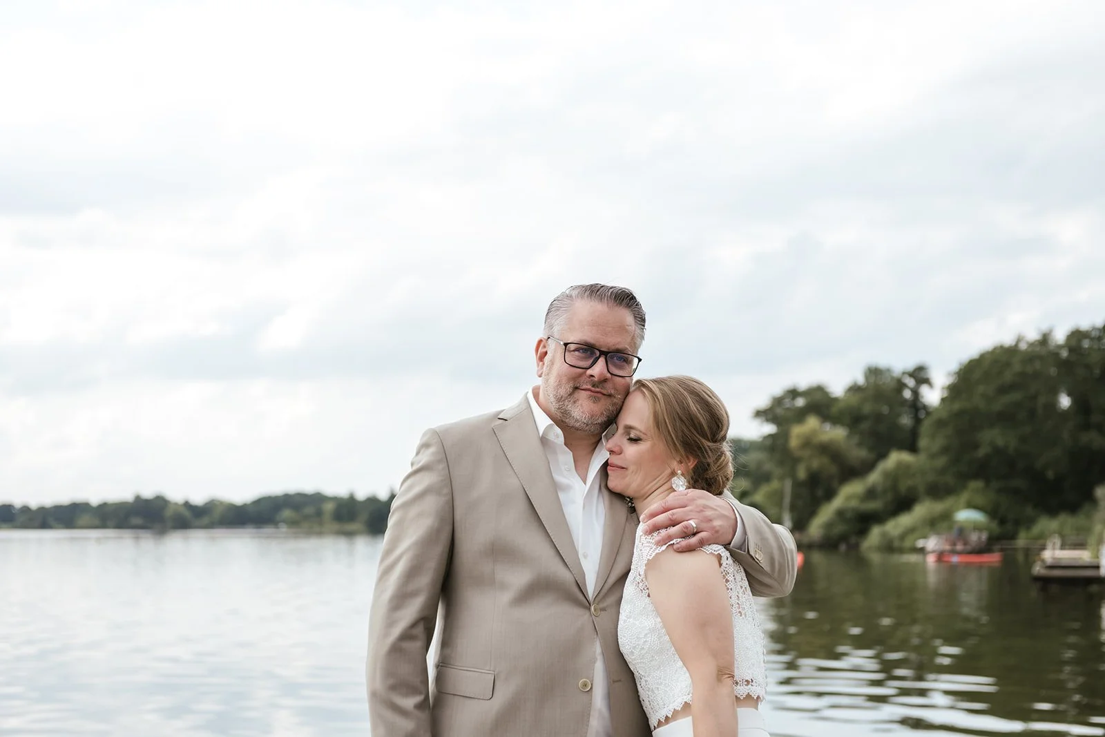 Brautpaar steht am See.