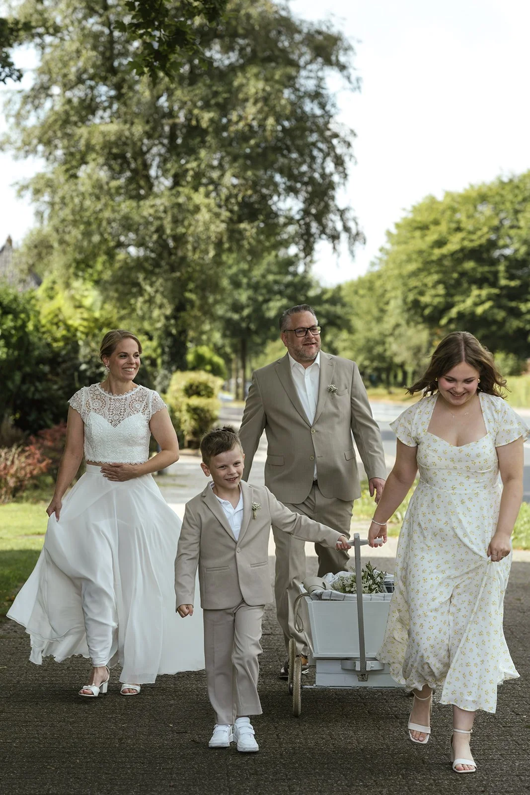 Braut. Bräutigam und die Kinder laufen zur Trauung.