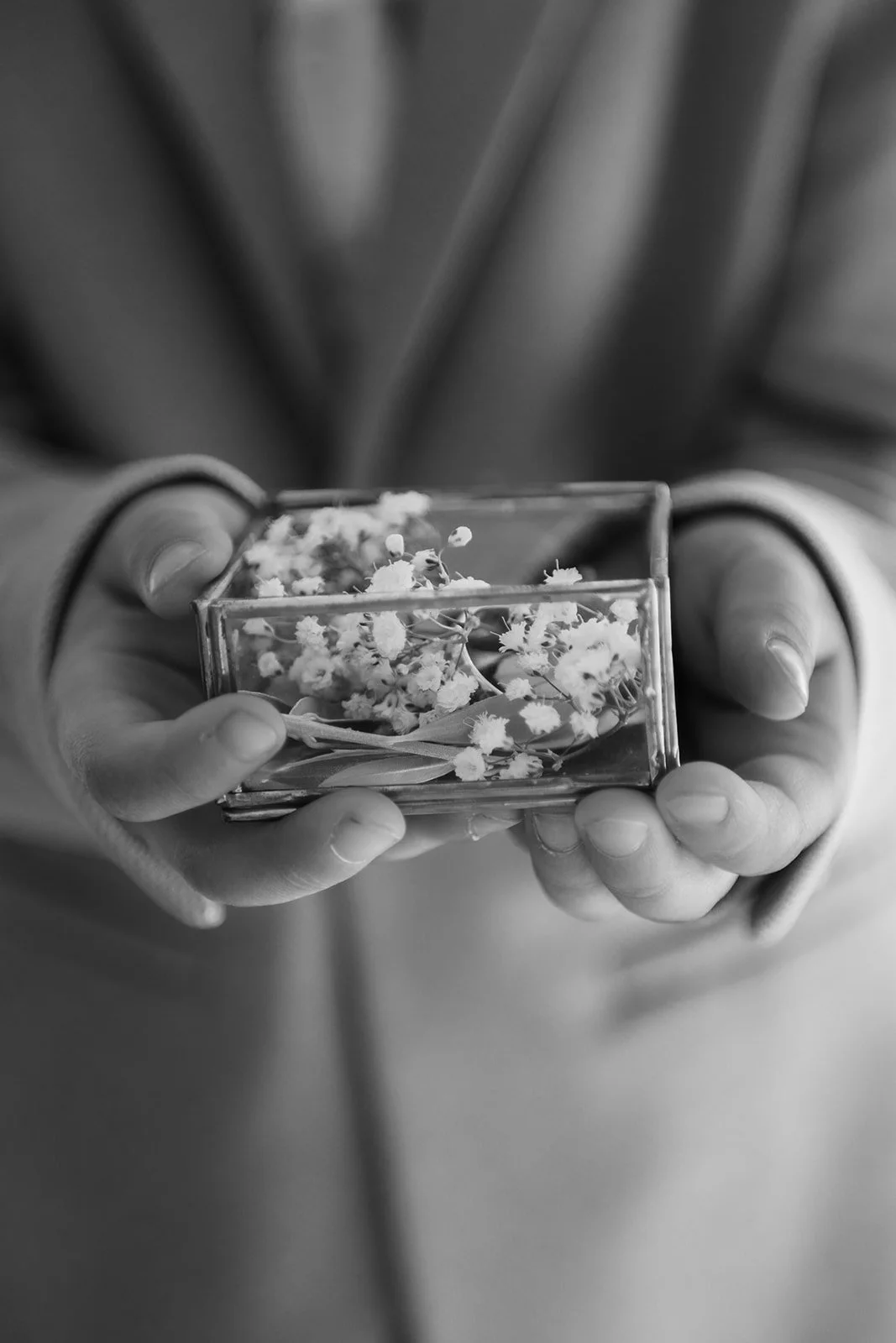 Nahaufnahme von Kinderhänden, die dei Eheringe halten.