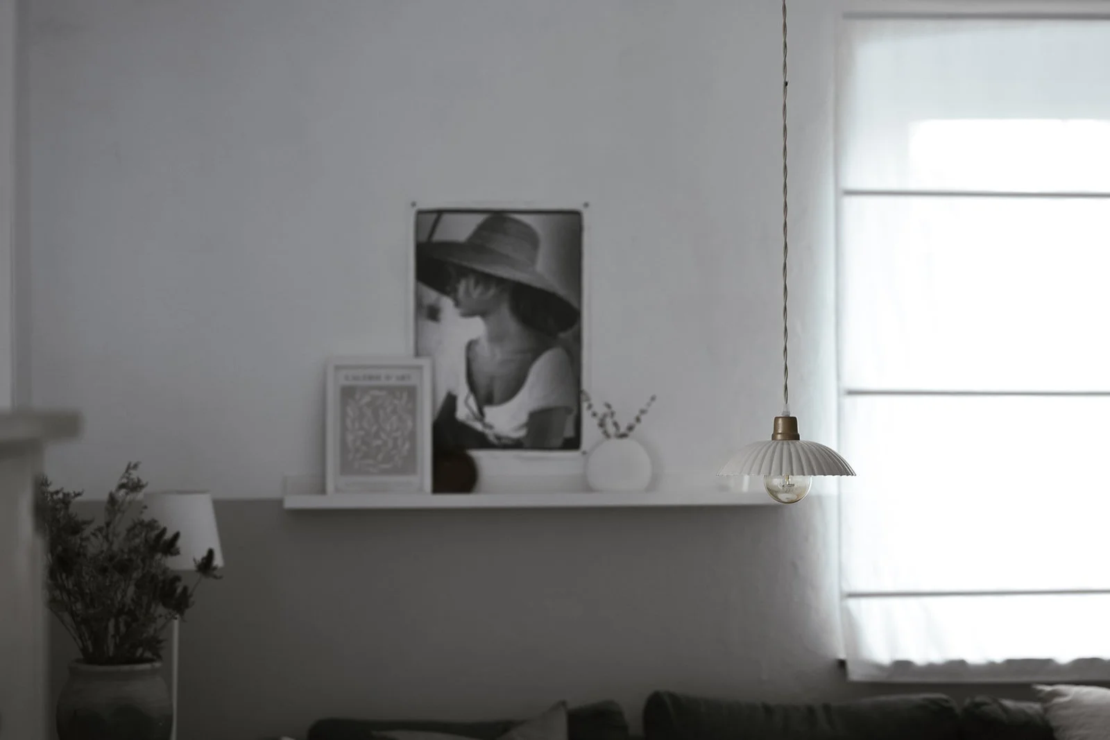 Aufnahme von einem gestylten Wohnzimmer mit Bilder an der Bildleiste und Hängelampe