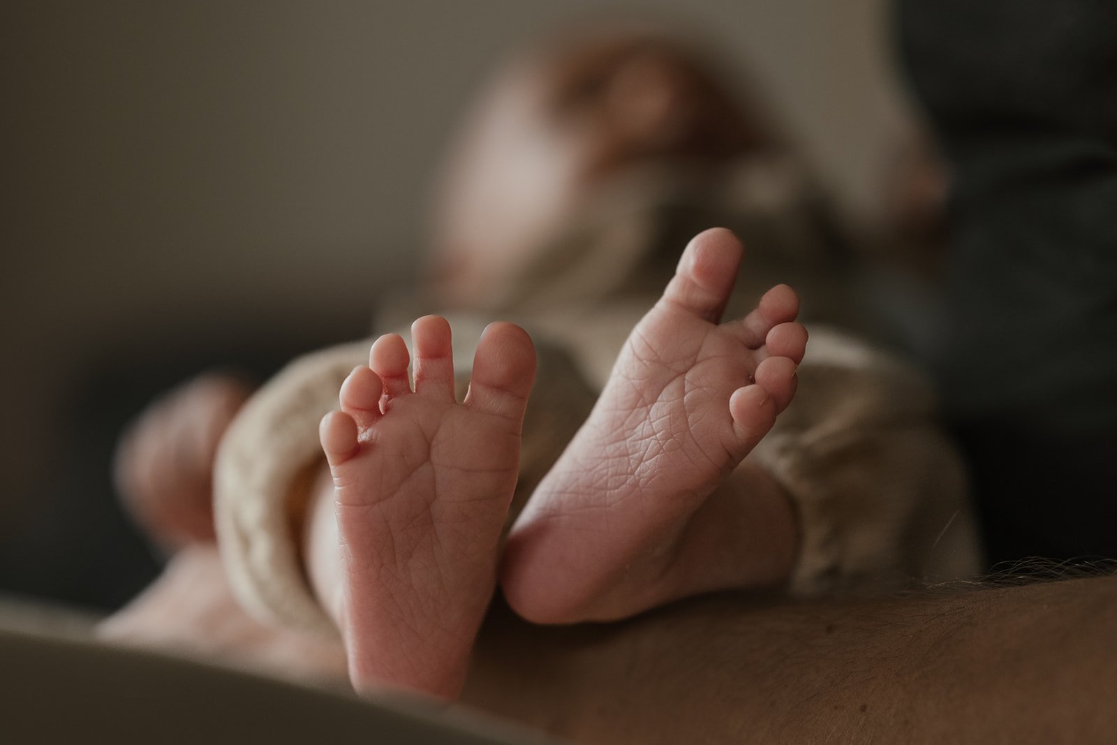 Nahaufnahme von einem Babyfüßchen, das auf einer Hand liegt.