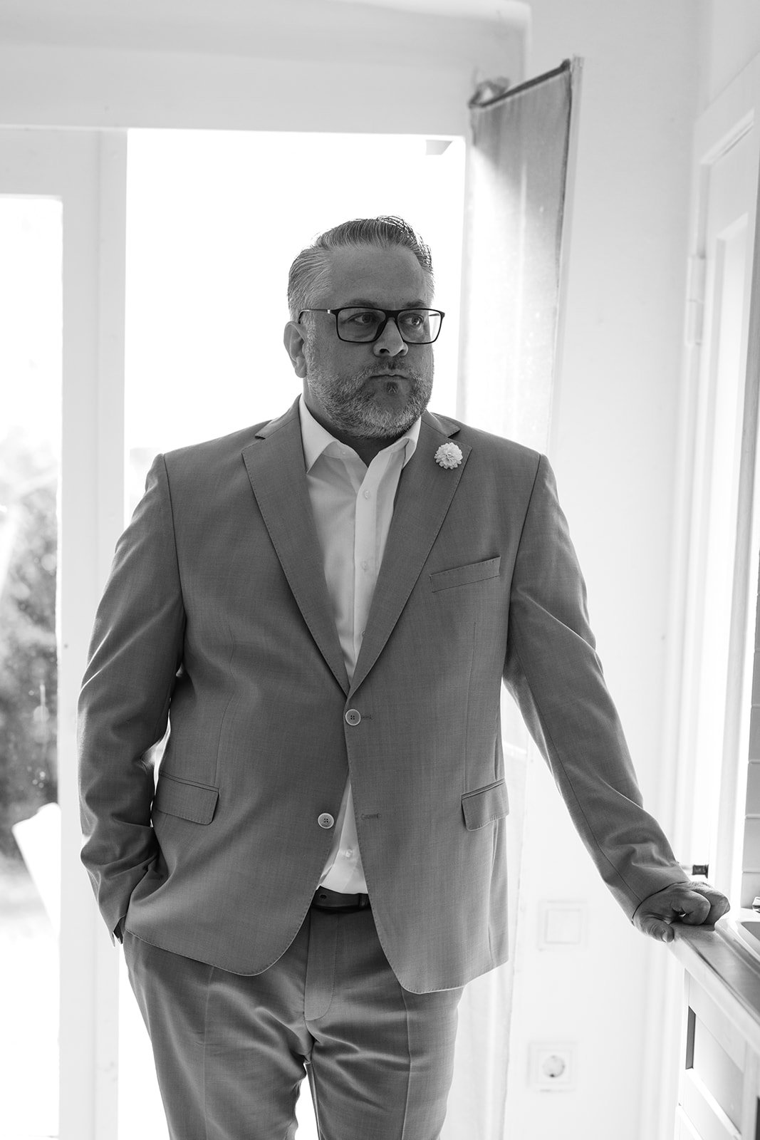 Bräutigam wartet auf die Braut in einem Raum. Momentaufnahme kurz vor dem First Look.