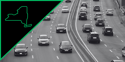 Multiple cars driving on a city street with multiple lanes.