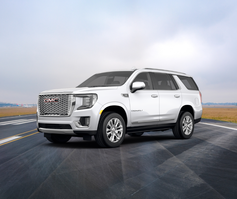 A white GMC Denali truck on an airport runway.