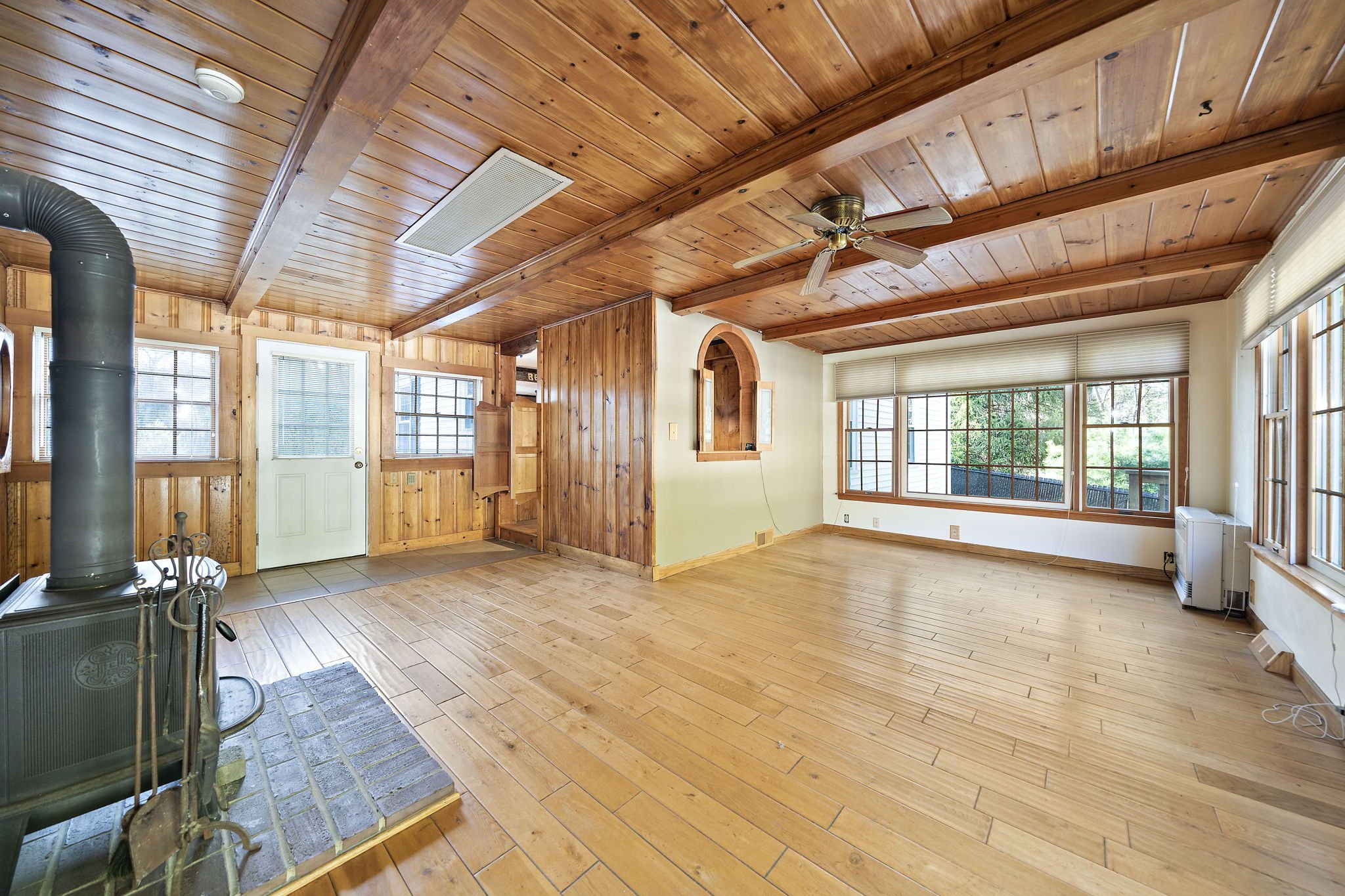 Enclosed breezeway with wood stove overlooking backyard pool Hanson MA home