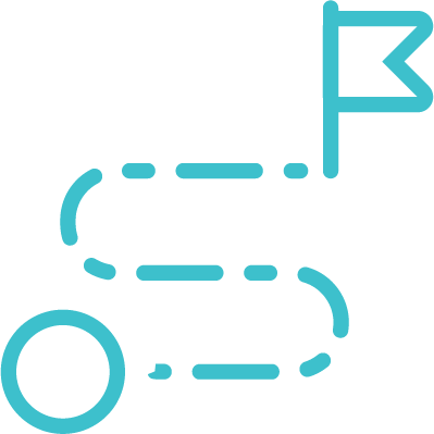 Two people sitting at a table, one typing on a laptop and the other writing in a notebook. The table has a vase with two white calla lilies, a glass of water, and a closed notebook with a pen.
