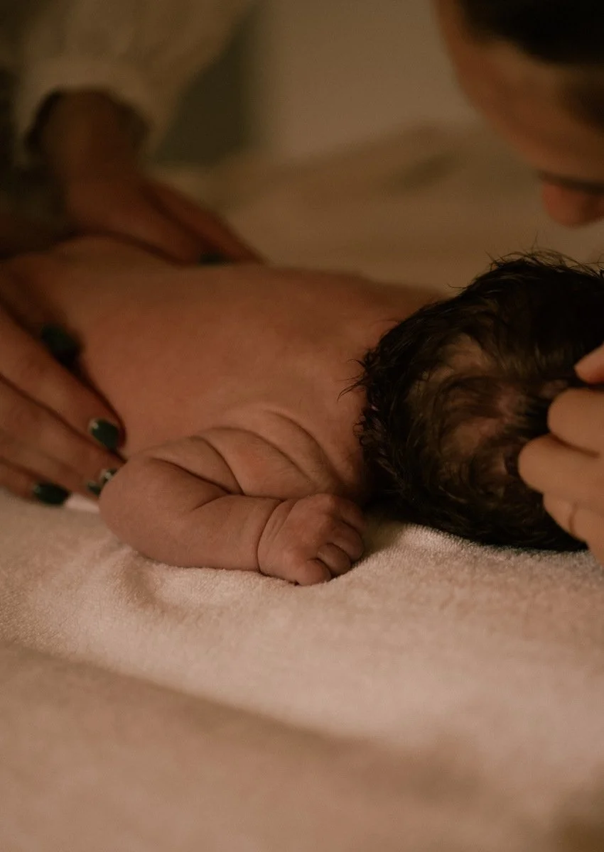 Nouveau-né allongé durant l'atelier massage bébé avec ses parents