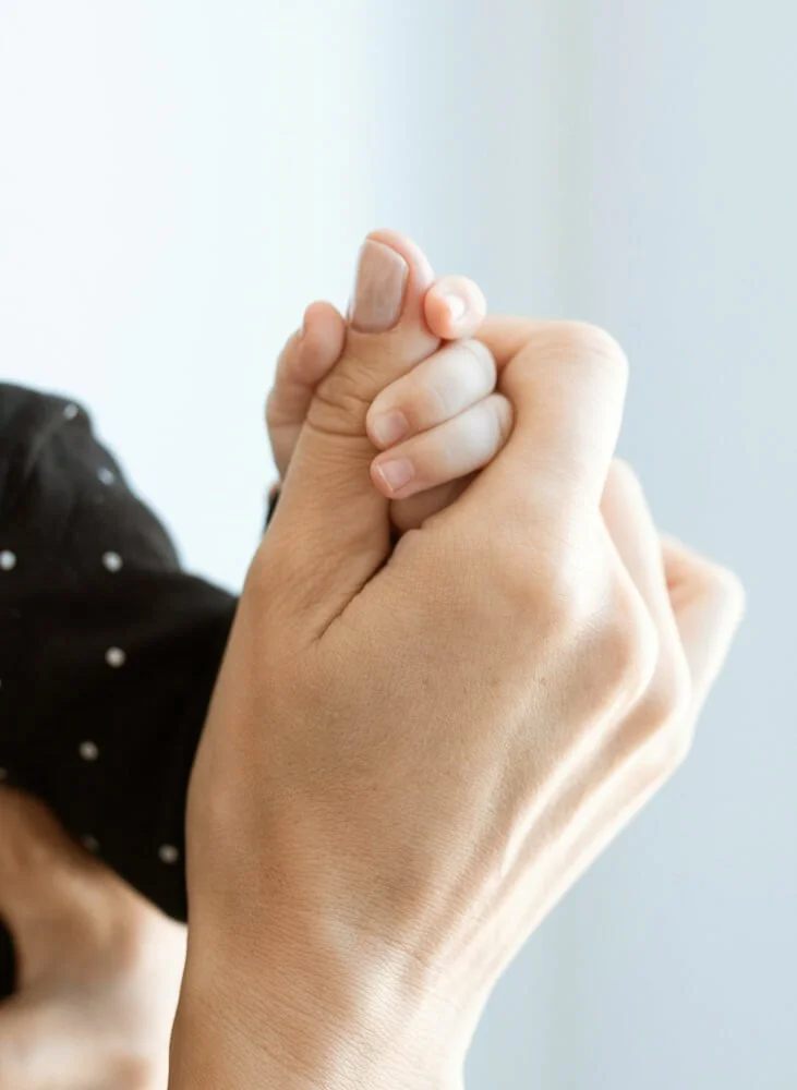 Maman tenant la main de son bébé de 6 mois