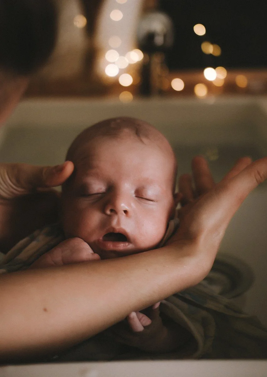 Nourisson endormi dans la baignoire pendant son bain thérapeutique bébé entouré de ses parents
